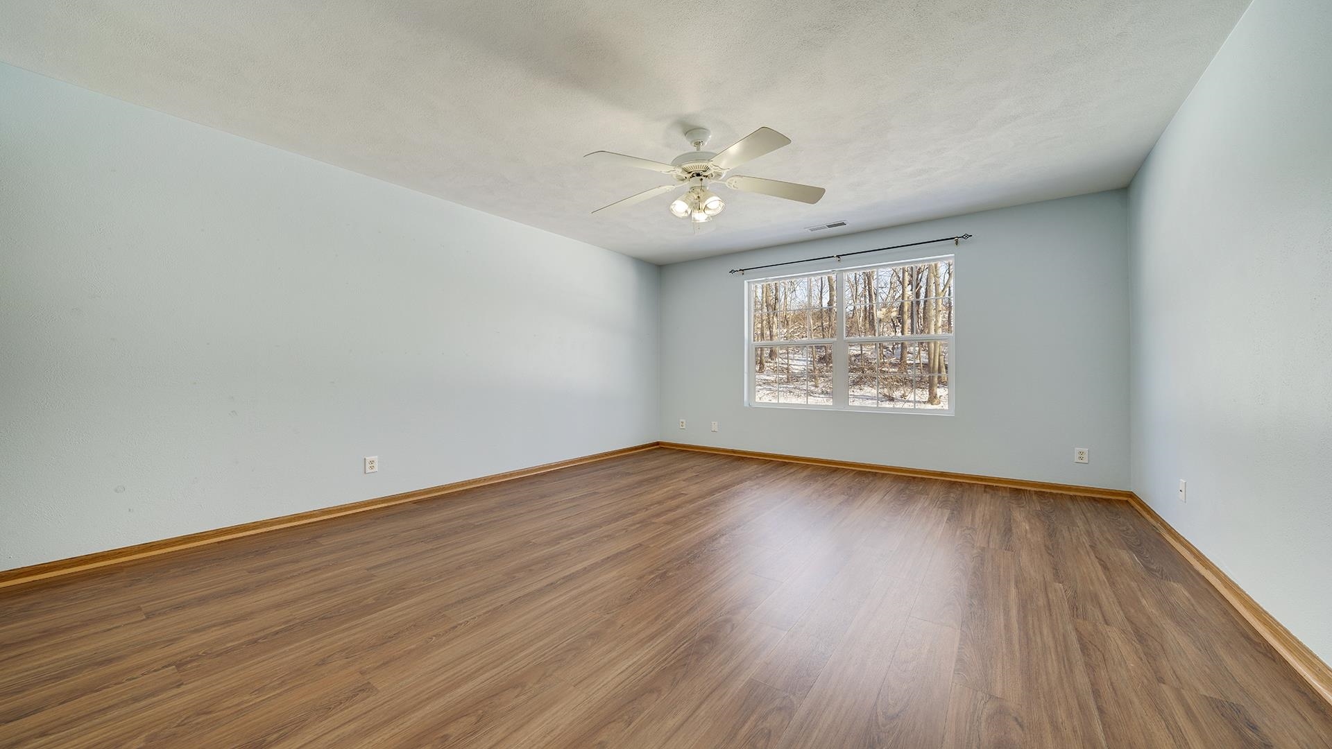 443 Mill Ridge Drive Byron, IL 61010 - Photo 18 of 25 an empty room with wooden floor chandelier fan and windows