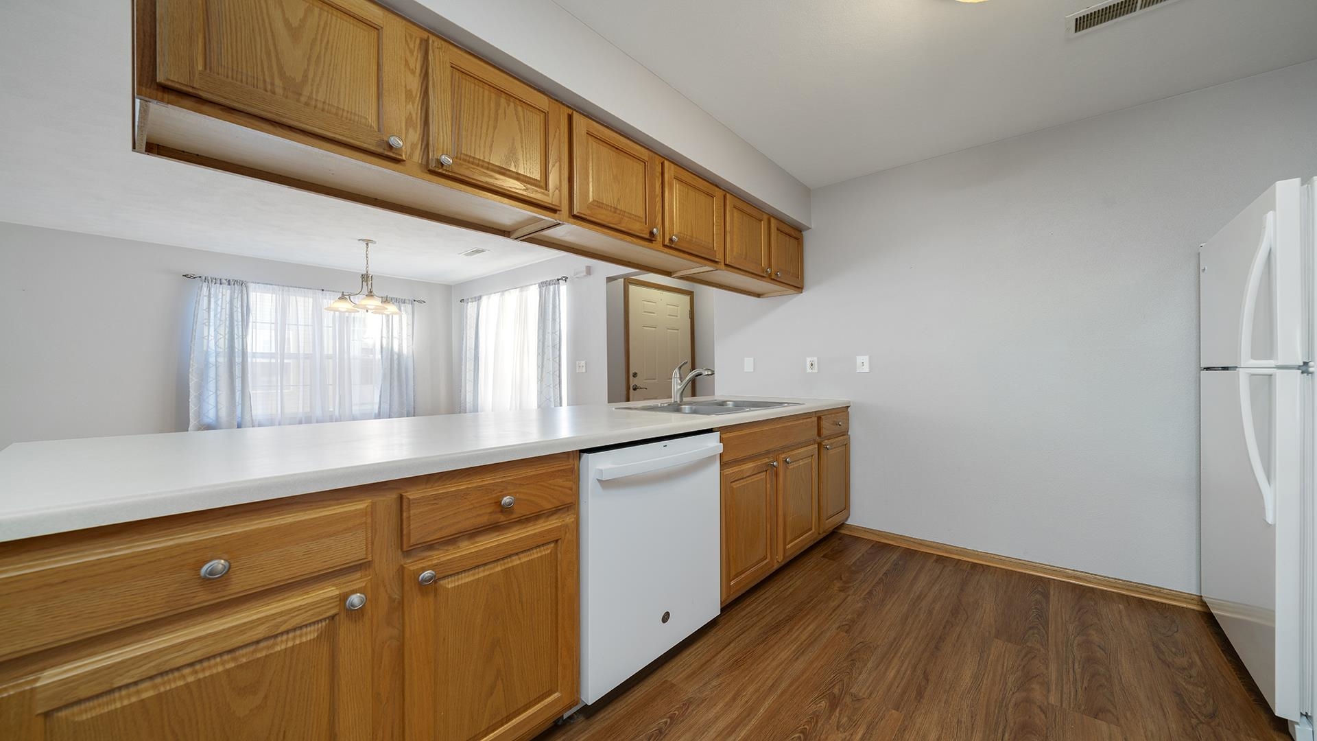 443 Mill Ridge Drive Byron, IL 61010 - Photo 9 of 25 a kitchen with granite countertop wooden floors and white stainless steel appliances