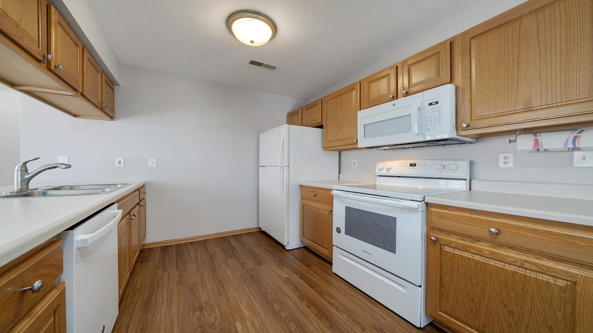 443 Mill Ridge Drive Byron, IL 61010 - Photo 10 of 25 a kitchen with wooden floors and white cabinets