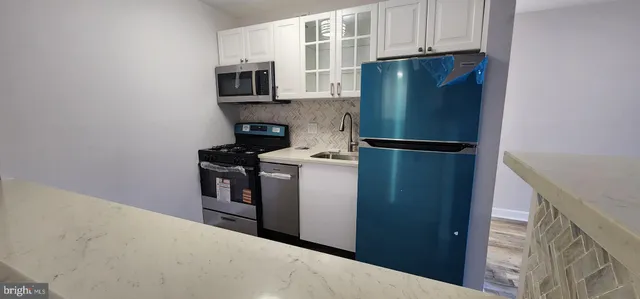 a kitchen with stainless steel appliances granite countertop a refrigerator and a microwave
