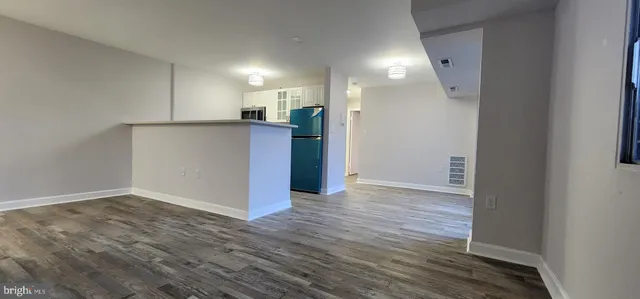 a view of a livingroom with kitchen and a window