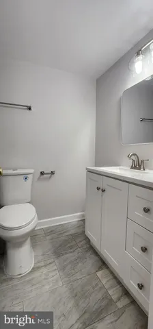 a bathroom with a toilet a sink a vanity and mirror