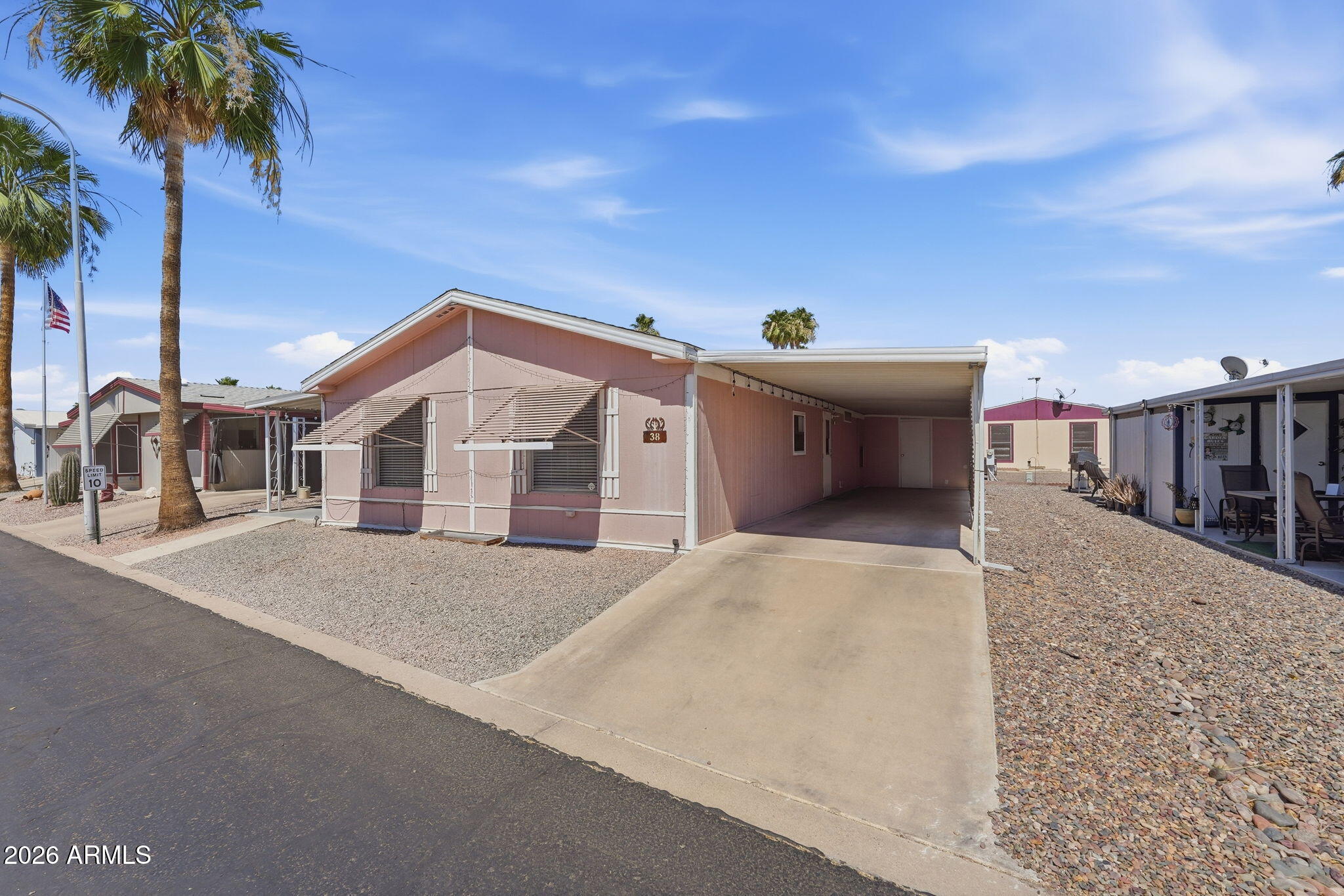 53 North Mountain Road, Unit 38 Apache Junction, AZ 85120 - Photo 3 of 35 a front view of a house with a yard and garage