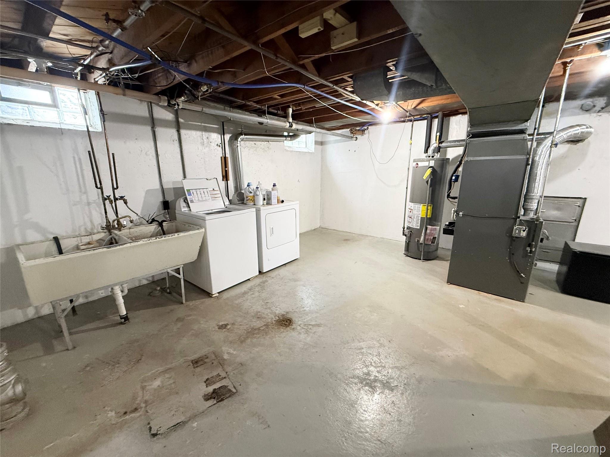 11012 Middlebelt Road Livonia, MI 48150 - Photo 12 of 14 Utility area featuring a laundry sink, exposed ceiling joists, and a concrete floor
