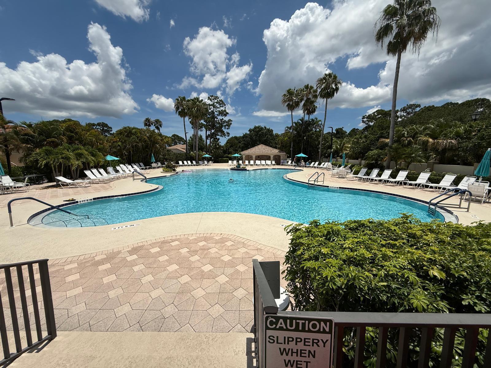 8294 Mulligan Circle, Unit B Port St. Lucie, FL 34986 - Photo 11 of 15 a view of a swimming pool with a patio and a garden