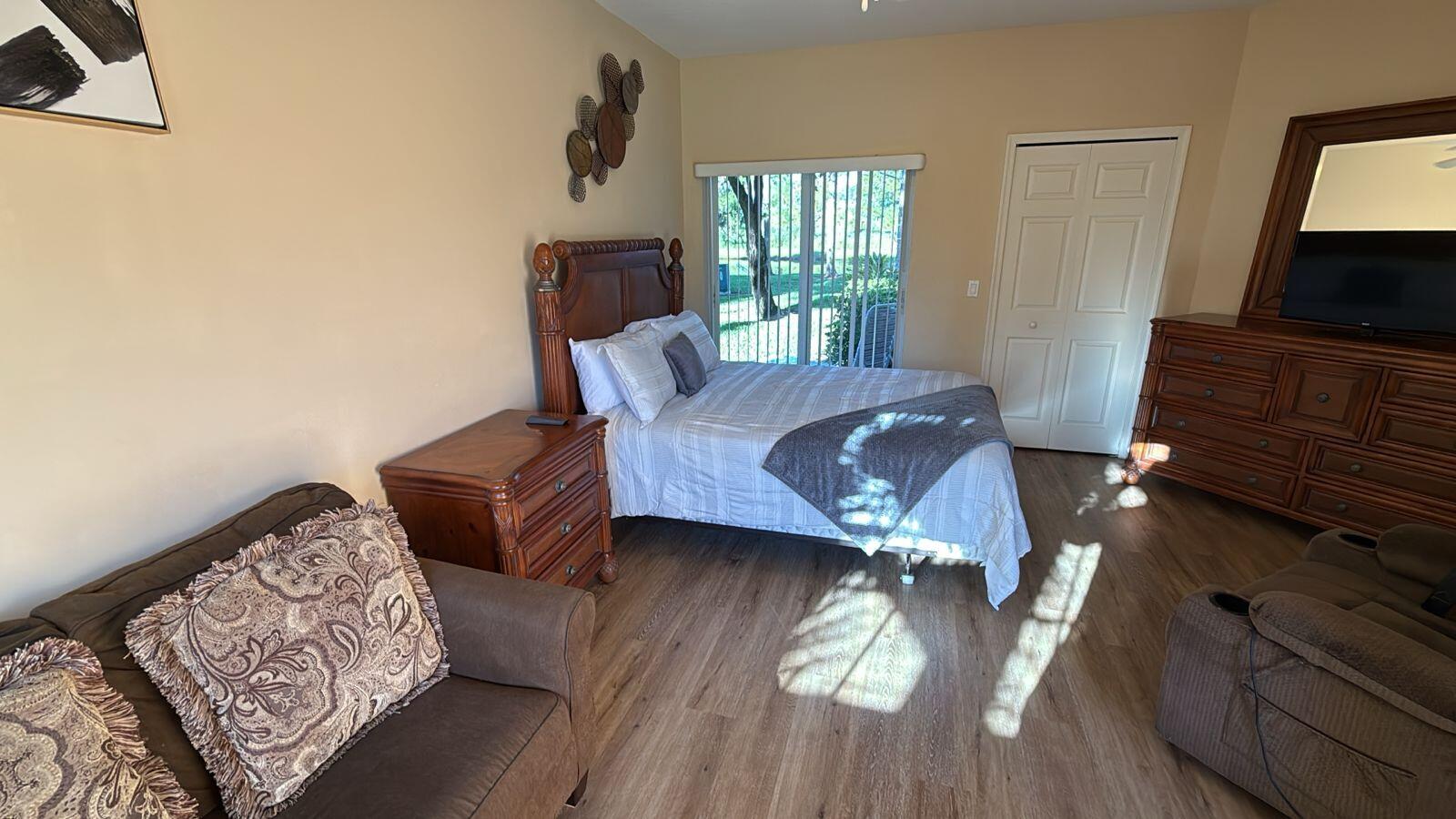 8294 Mulligan Circle, Unit B Port St. Lucie, FL 34986 - Photo 2 of 15 a living room with furniture and a flat screen tv