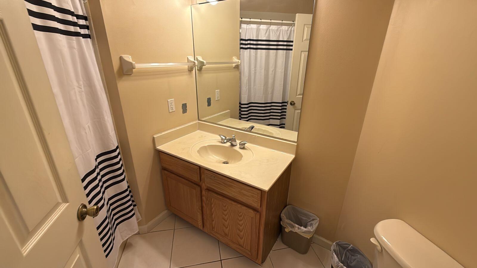 8294 Mulligan Circle, Unit B Port St. Lucie, FL 34986 - Photo 6 of 15 a bathroom with a sink a toilet and a mirror