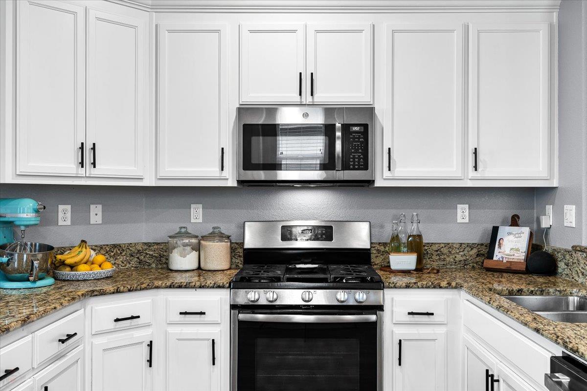 6617 Cervi Road Riverbank, CA 95367 - Photo 15 of 51 a kitchen with stainless steel appliances granite countertop white cabinets and a stove