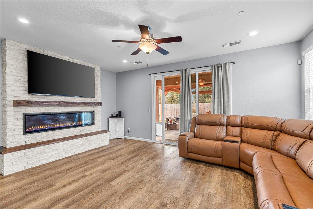 6617 Cervi Road Riverbank, CA 95367 - Photo 19 of 51 a living room with furniture a flat screen tv and a fireplace