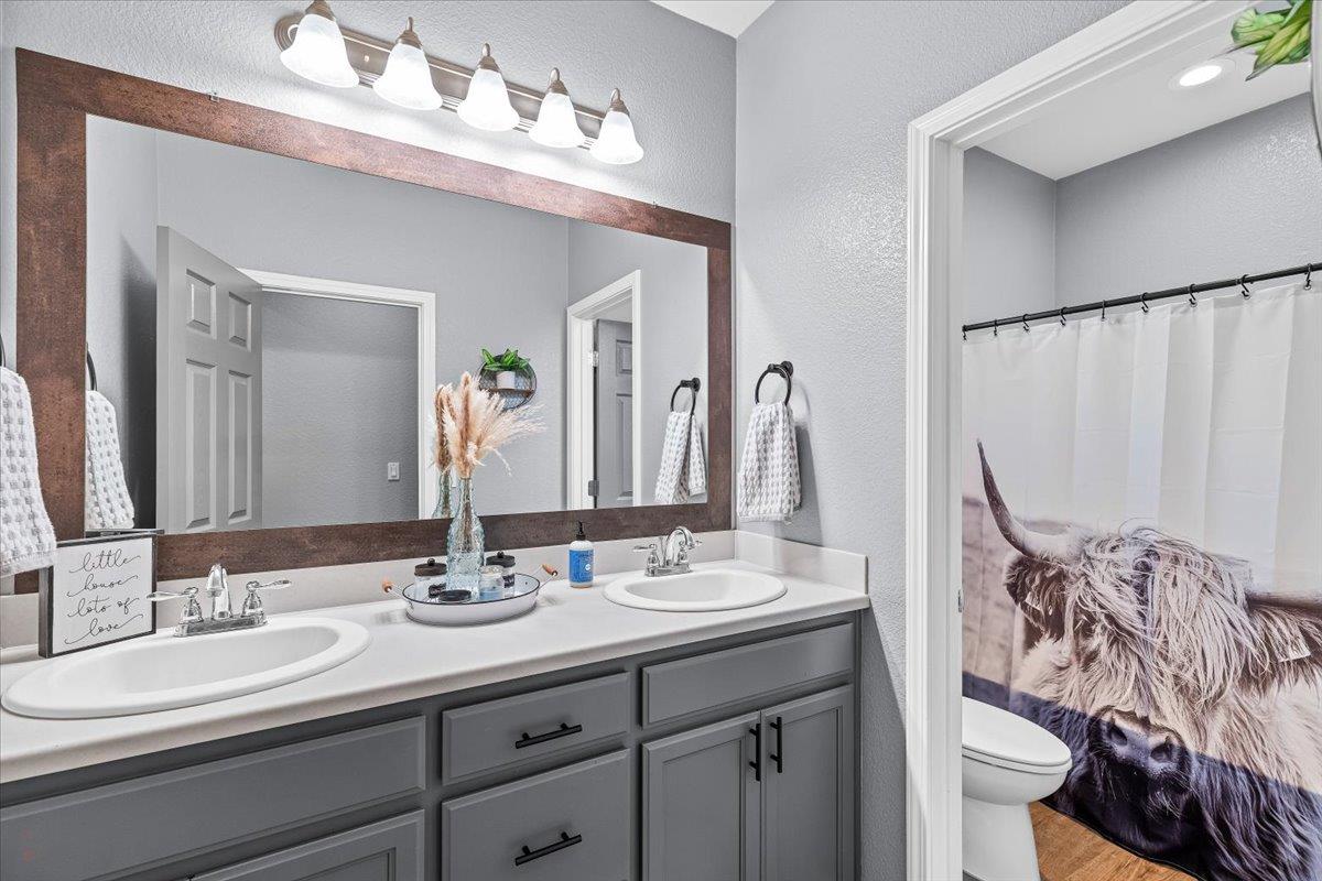 6617 Cervi Road Riverbank, CA 95367 - Photo 28 of 51 a bathroom with a double vanity sink and a mirror