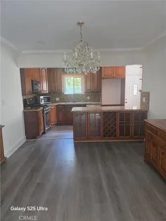 a kitchen with stainless steel appliances granite countertop a stove and a wooden floors