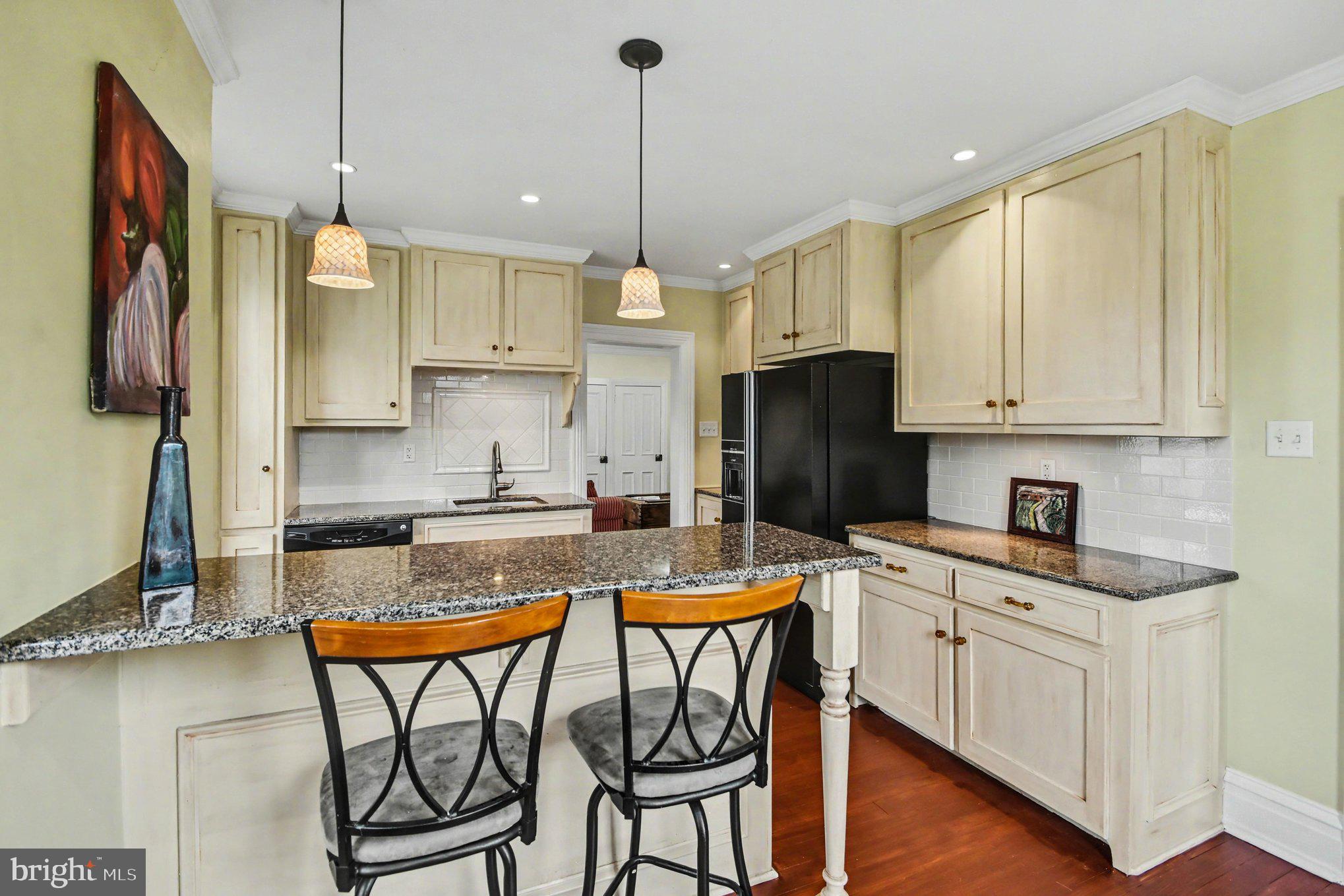 9627 Easton Road Upper Black Eddy, PA 18972 - Photo 5 of 28 a kitchen with stainless steel appliances granite countertop a stove a refrigerator a sink a dining table and chairs with wooden floor