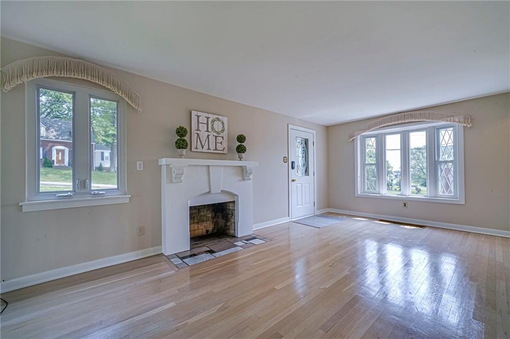 12 Kennedy Lane McKees Rocks, PA 15136 - Photo 10 of 29 an empty room with windows fireplace and wooden floor