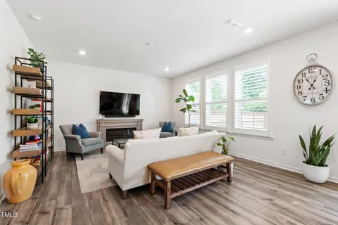 a living room with furniture a bookshelf and a flat screen tv