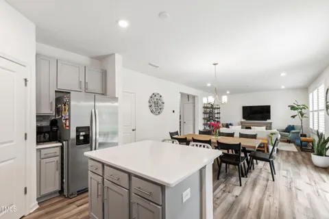 a kitchen that has a lot of white cabinets and stainless steel appliances
