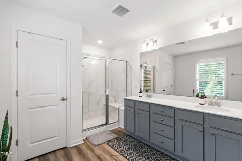a bathroom with a double vanity sink a mirror and a shower