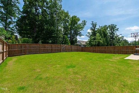 a view of yard with green space and wooden fence