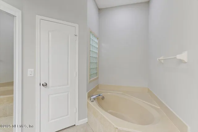 a white bath tub sitting next to a white cabinet