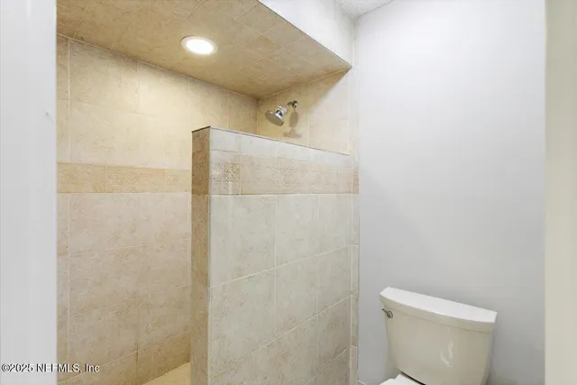 a bathroom with a toilet and a shower
