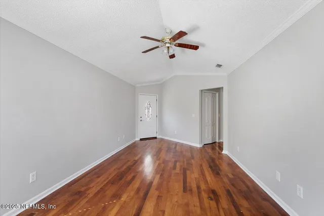 a view of empty room with wooden floor
