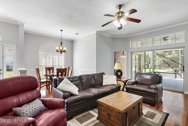 a living room with furniture a chandelier and a large window