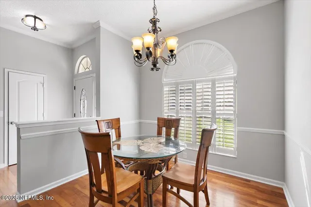 a view of a dining room with furniture a chandelier and wooden floor