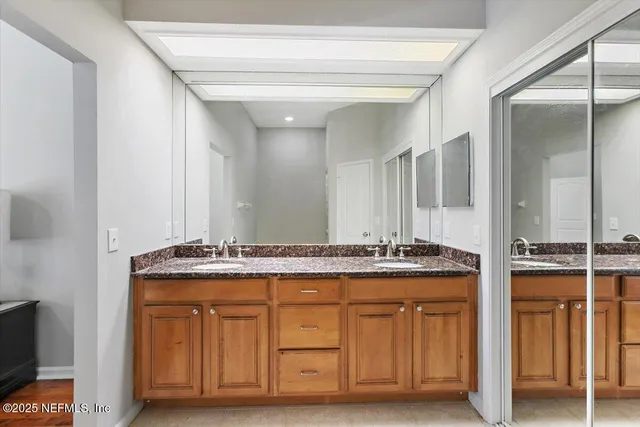 a bathroom with a granite countertop sink and a mirror