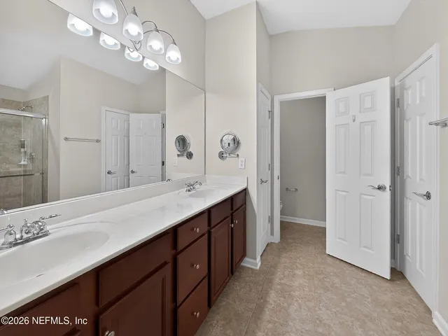 a living room with couches a fireplace and a dining table with garden view
