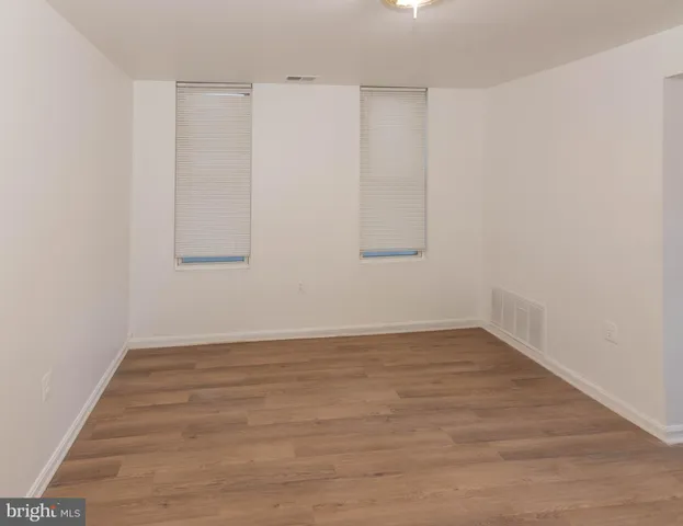 a view of an empty room with wooden floor