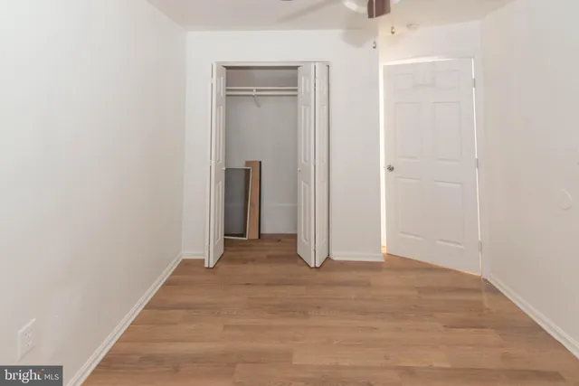 an empty room with wooden floor and closet