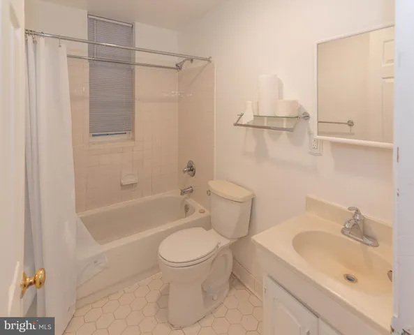 a white toilet sitting next to a bath tub