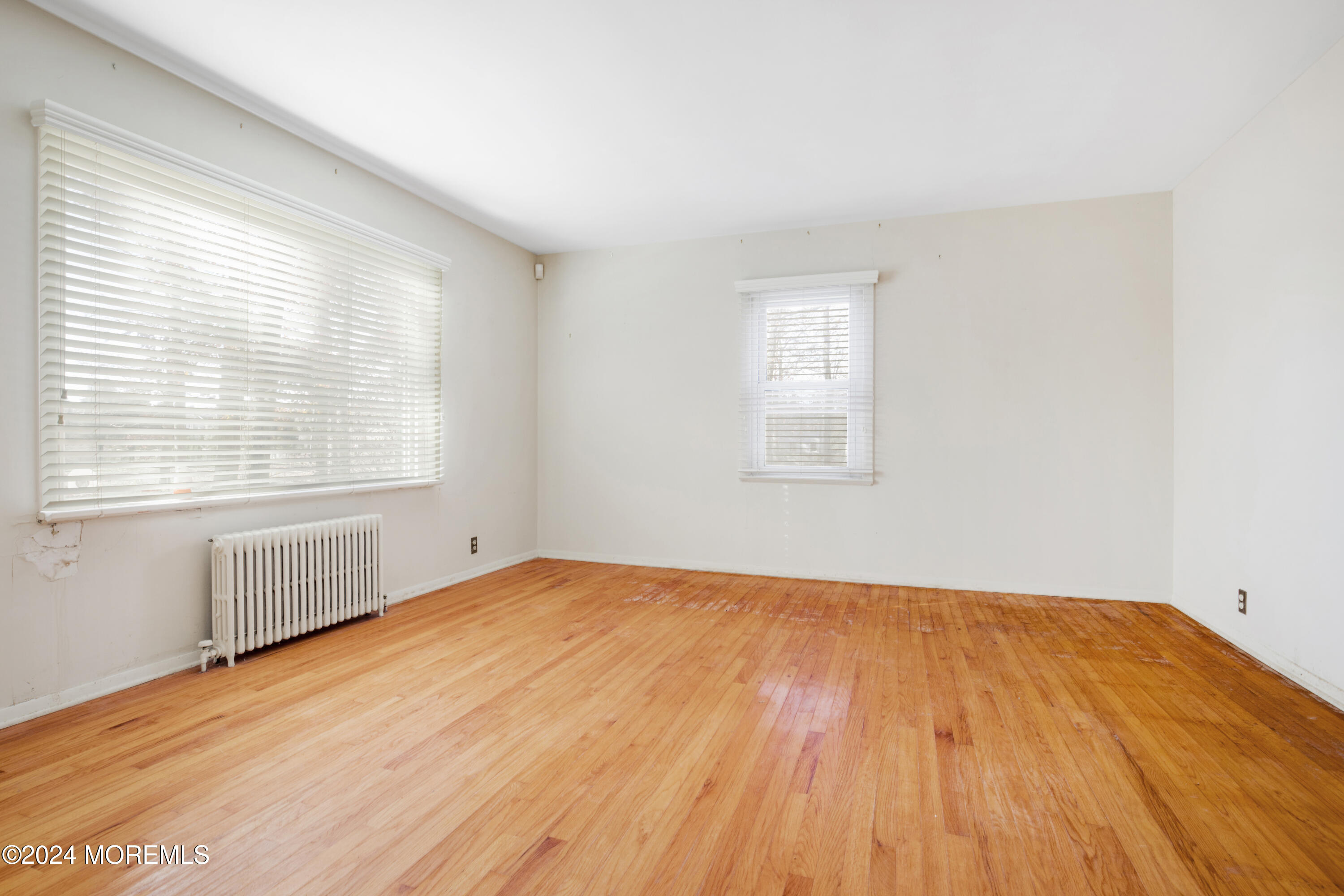 552 Hyson Road Jackson, NJ 08527 - Photo 4 of 23 an empty room with wooden floor and windows