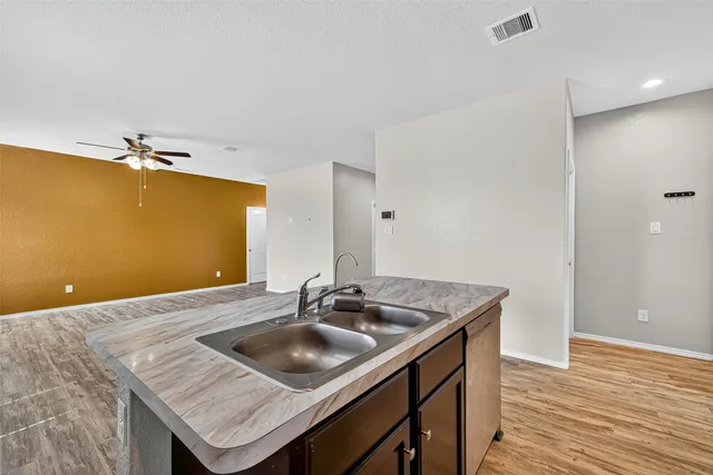 a kitchen with a sink a microwave and wooden floor