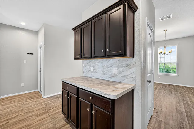 a bathroom with a sink a mirror and wooden floor