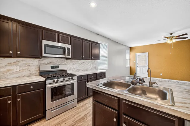 a kitchen with a sink stove and microwave