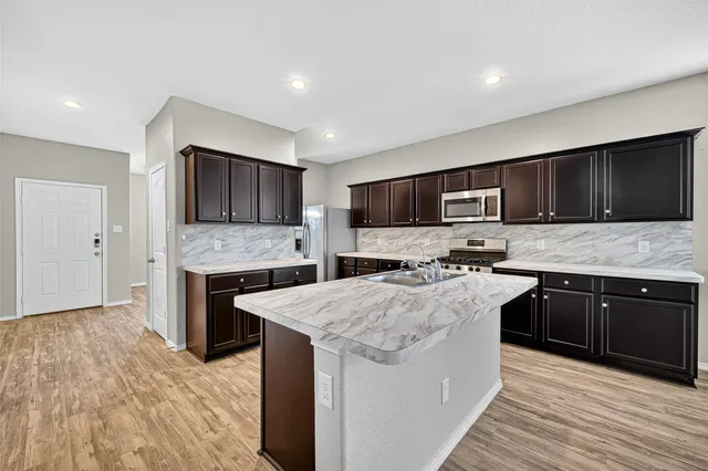 a kitchen with a sink stove top oven and refrigerator