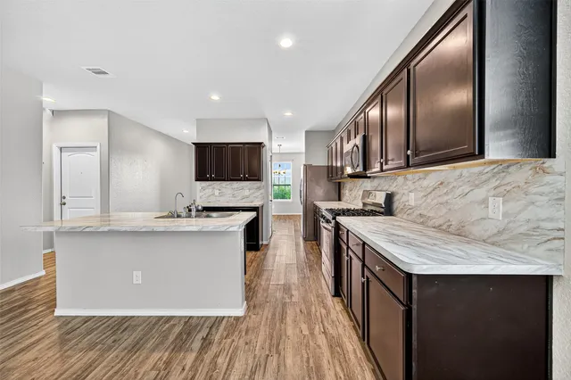 a kitchen with stainless steel appliances granite countertop a sink stove and oven
