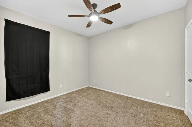 an empty room with closet and windows