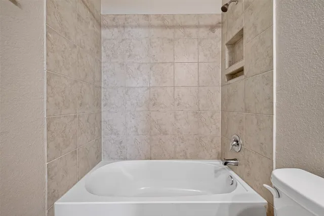a white bath tub sitting next to a toilet