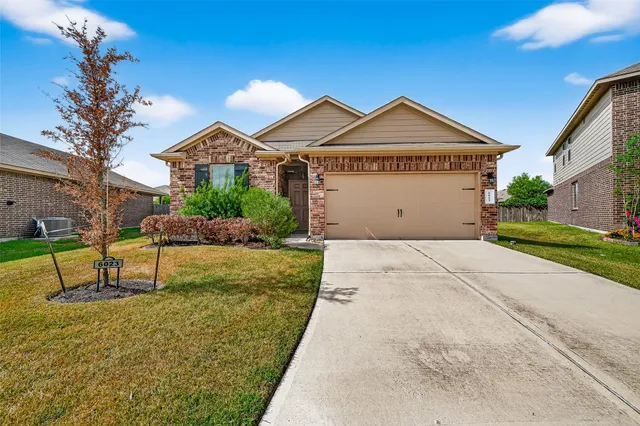 a view of a house with a yard and potted plants