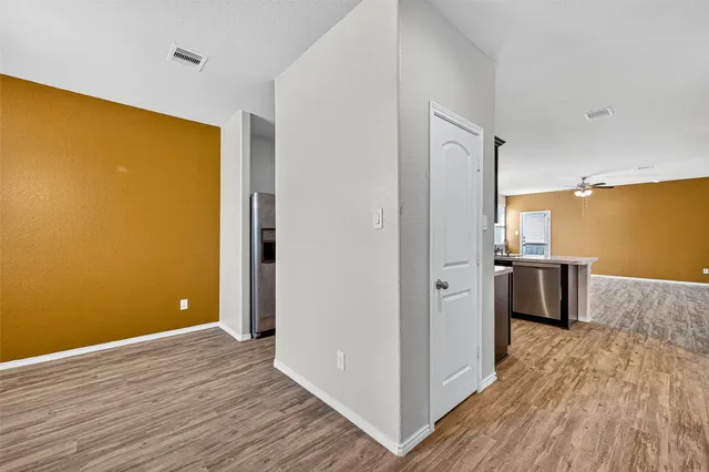 a view of a kitchen with a fridge and wooden floor
