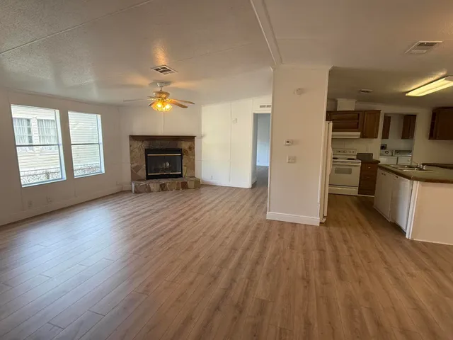 a kitchen with sink a refrigerator and wooden floor