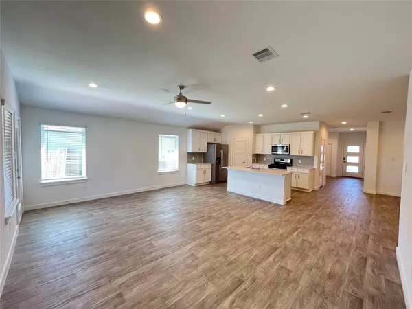 a view of kitchen with kitchen island wooden floor and center island