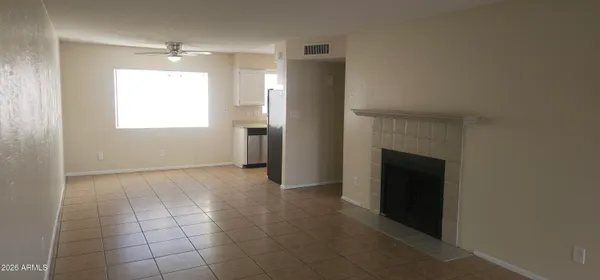 a view of an empty room with a fireplace and a window