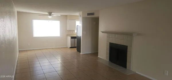 a view of an empty room with a fireplace and a window