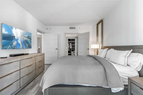 a spacious bedroom with a large bed and a large mirror