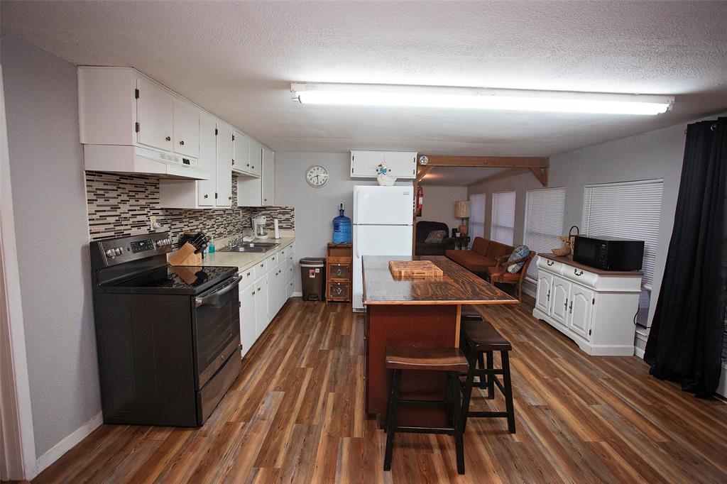 9051 Lacy Road Graford, TX 76449 - Photo 7 of 23 a kitchen with stainless steel appliances a stove a sink and a refrigerator