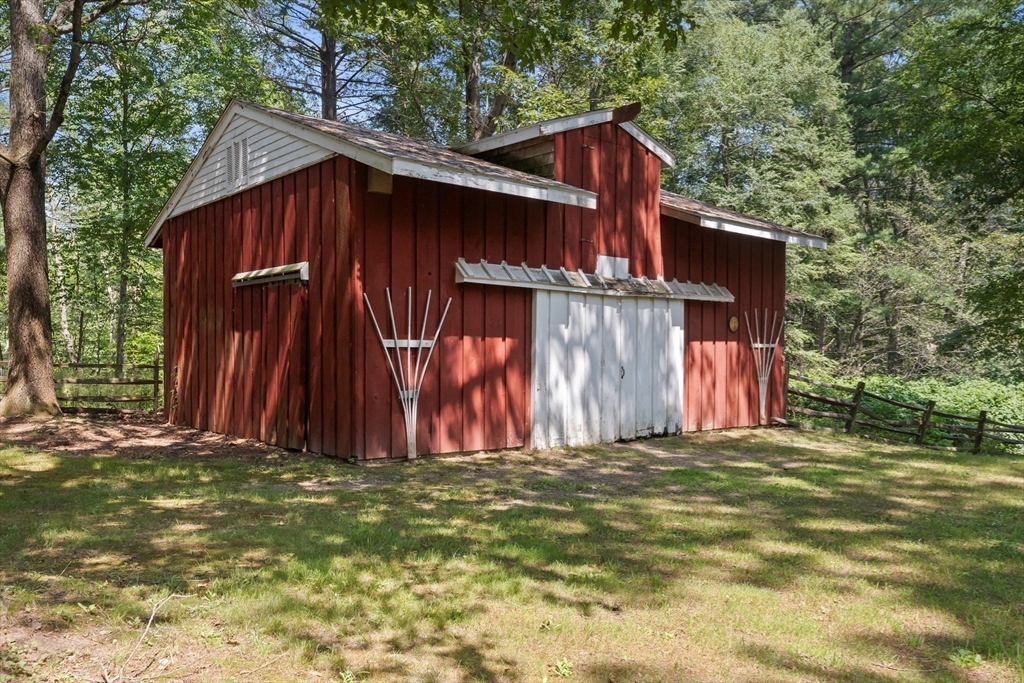 118 Echo Cove Road Hamilton, MA 01982 - Photo 27 of 40 a view of a wooden house with large trees and a small yard