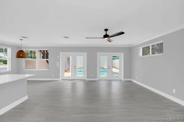 an empty room with wooden floor and windows
