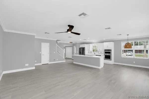 a large white kitchen with stainless steel appliances